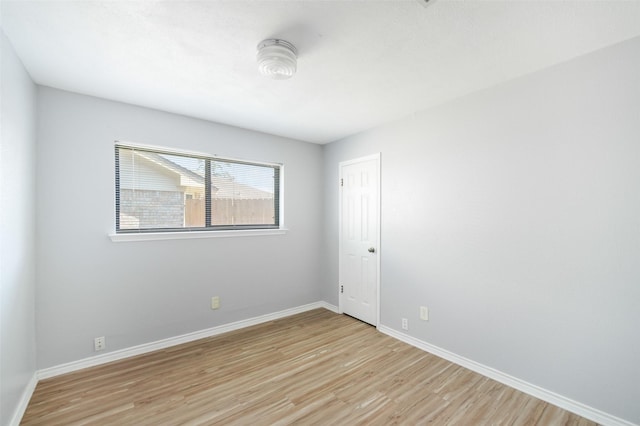 spare room with light wood finished floors and baseboards