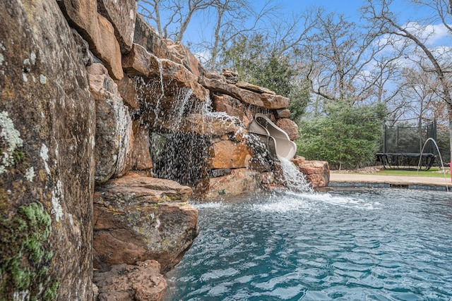 view of swimming pool with a trampoline