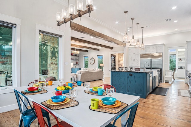 dining room with plenty of natural light, light wood-style flooring, crown molding, and beamed ceiling