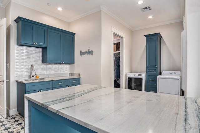 kitchen with blue cabinets, visible vents, a sink, and ornamental molding