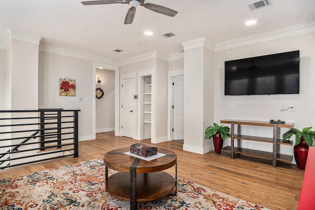 living room featuring ornamental molding, visible vents, and light wood-style floors