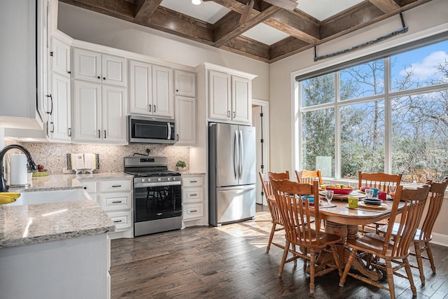 kitchen featuring appliances with stainless steel finishes, a sink, hardwood / wood-style floors, and tasteful backsplash