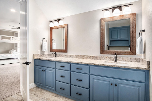 bathroom featuring double vanity, a sink, and wood finished floors