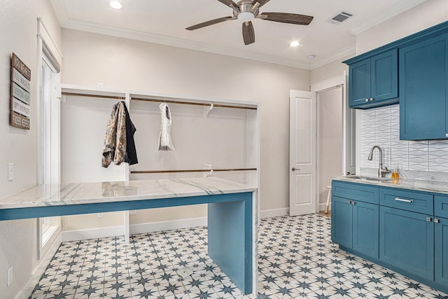 interior space featuring ornamental molding, a sink, visible vents, and blue cabinets