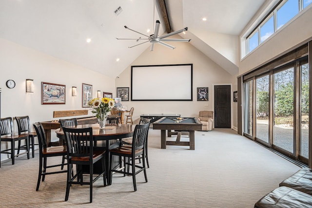 dining room with beam ceiling, a wealth of natural light, and light colored carpet