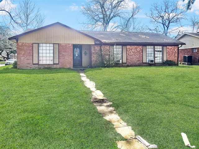 single story home featuring brick siding, a front lawn, a shingled roof, and cooling unit