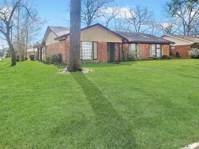 exterior space featuring brick siding and a lawn