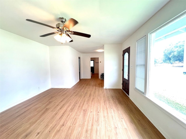 unfurnished room featuring ceiling fan, baseboards, and wood finished floors