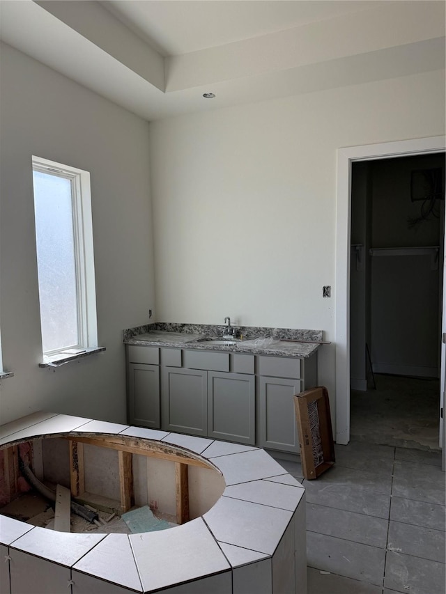 kitchen with light countertops, gray cabinets, and a sink