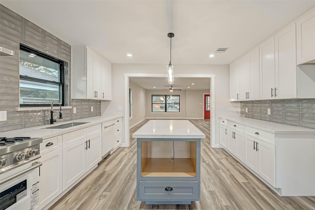 2111 Nina Lee Ln, Houston, TX 77018 - kitchen featuring light countertops, backsplash, a sink, light wood finished floors, and stainless steel range