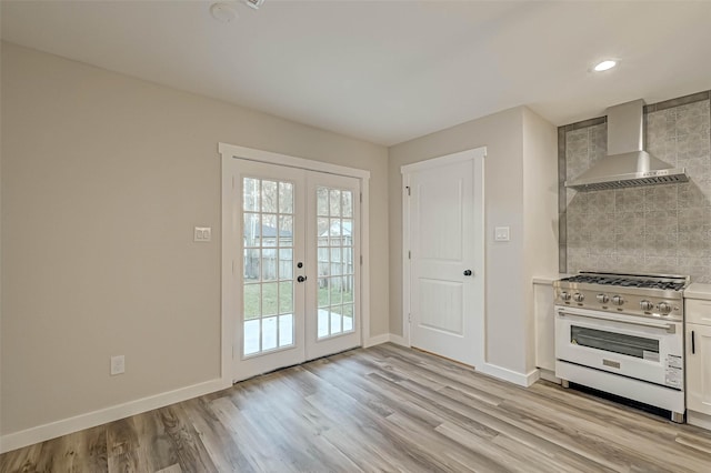 2111 Nina Lee Ln, Houston, TX 77018 - kitchen featuring tasteful backsplash, french doors, baseboards, stainless steel range, and wall chimney exhaust hood