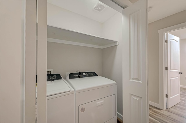2111 Nina Lee Ln, Houston, TX 77018 - clothes washing area featuring visible vents, baseboards, laundry area, light wood-style floors, and washer and clothes dryer
