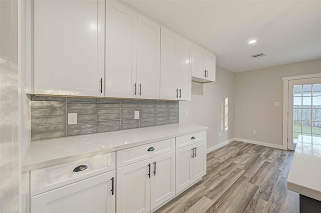 2111 Nina Lee Ln, Houston, TX 77018 - kitchen featuring baseboards, light countertops, light wood-type flooring, and white cabinets