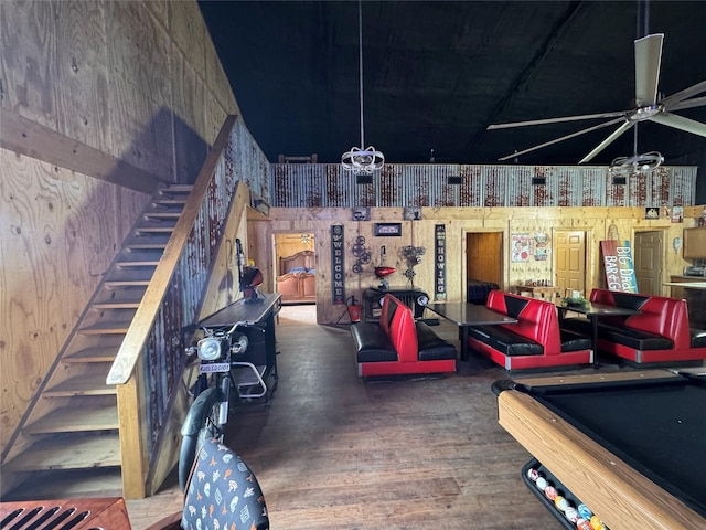 interior space featuring ceiling fan with notable chandelier, wood finished floors, and pool table