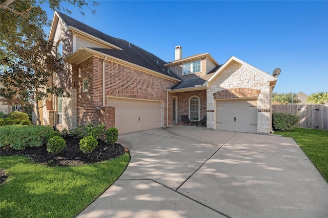 view of front of home with brick siding, fence, a garage, stone siding, and driveway