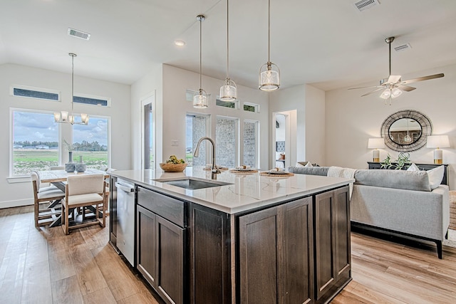 187 Peninsula Point Dr, Montgomery, TX 77356 - kitchen with a sink, light wood-type flooring, dark brown cabinets, light stone counters, and open floor plan