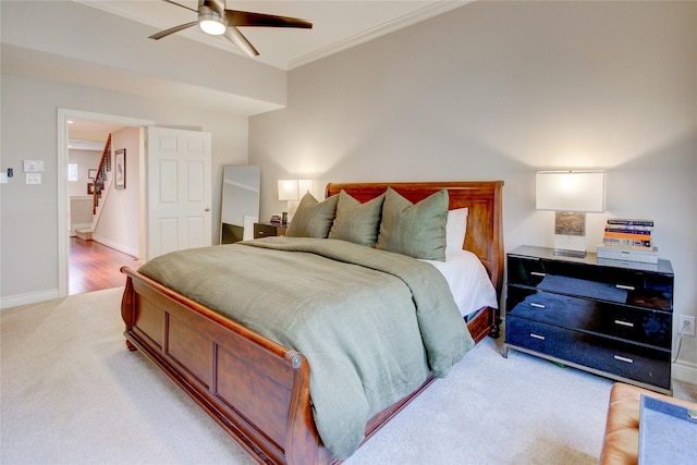 bedroom with baseboards, light colored carpet, ceiling fan, and crown molding