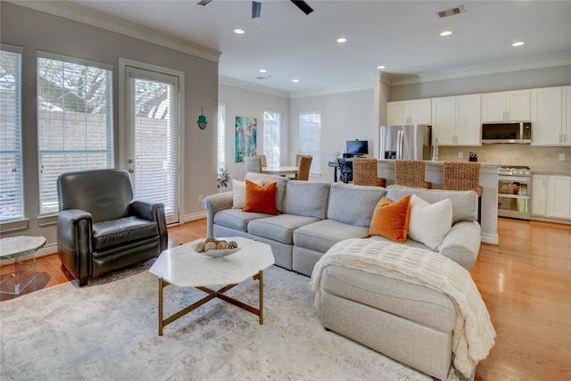 living room featuring visible vents, ornamental molding, recessed lighting, light wood finished floors, and baseboards