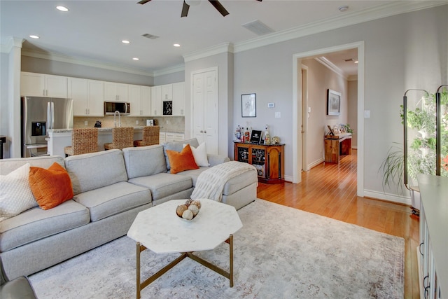 living area with light wood finished floors, visible vents, recessed lighting, and baseboards