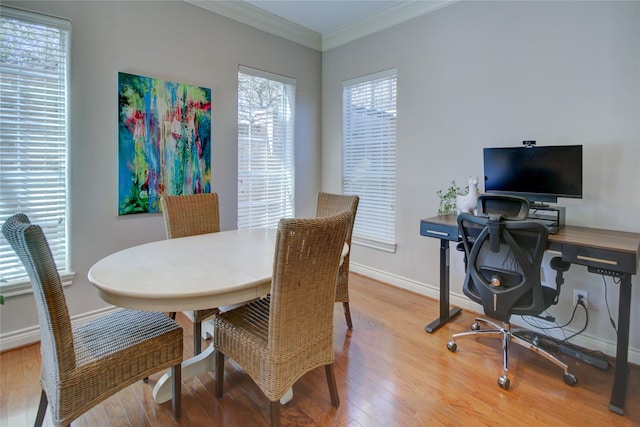 dining room featuring baseboards, light wood-style flooring, and crown molding