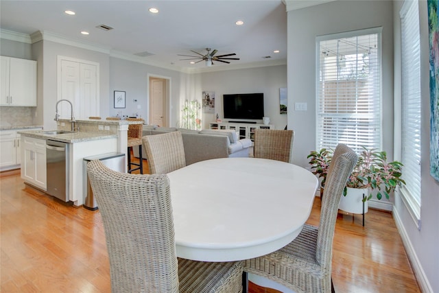 dining room with a wealth of natural light, light wood-style floors, ornamental molding, and recessed lighting