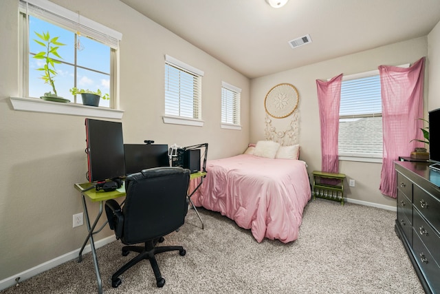 carpeted bedroom featuring visible vents, baseboards, and multiple windows