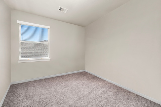 carpeted empty room with visible vents and baseboards