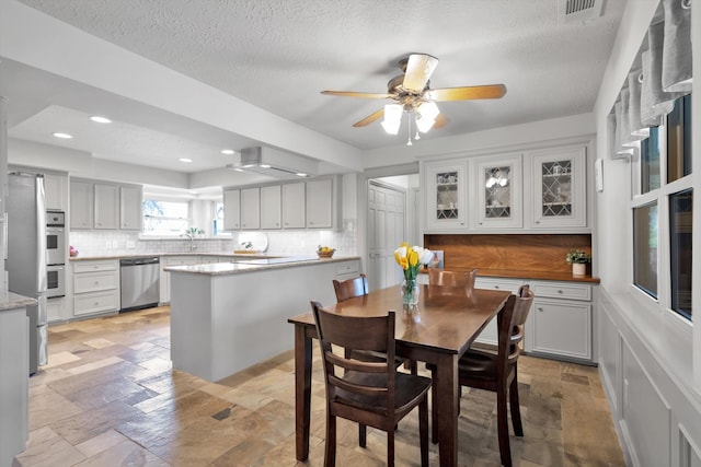 dining space featuring a textured ceiling, visible vents, stone tile flooring, and recessed lighting