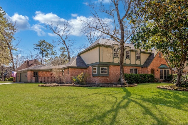 view of front of house with brick siding, a front lawn, an attached garage, and stucco siding