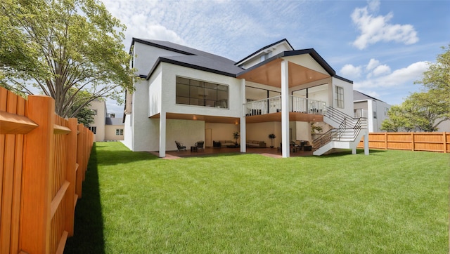 back of house featuring stucco siding, a lawn, a patio area, a fenced backyard, and stairs