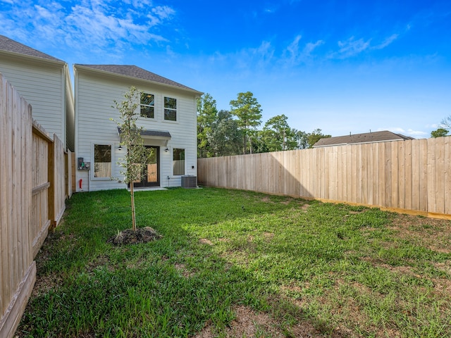 view of yard with a fenced backyard and central AC