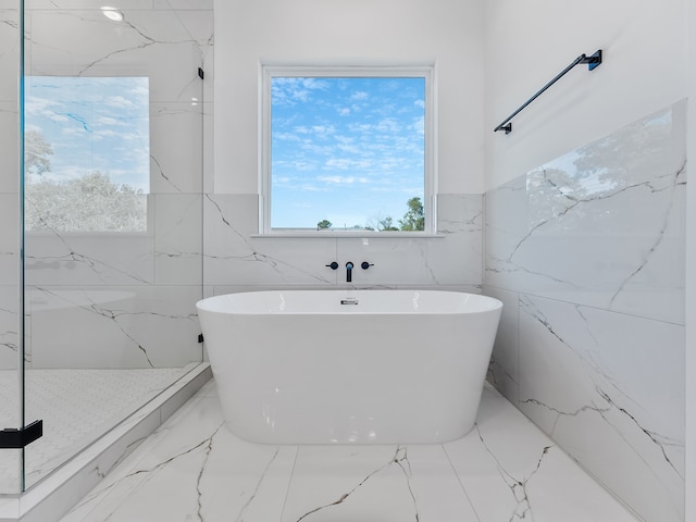 full bathroom with a soaking tub, marble finish floor, and a shower