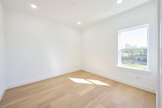 empty room featuring recessed lighting, light wood-type flooring, and baseboards