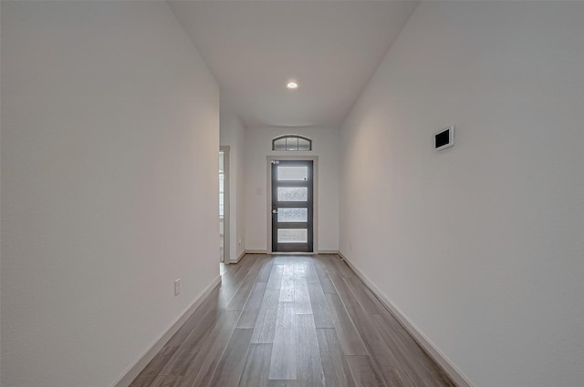 doorway featuring baseboards and wood finished floors