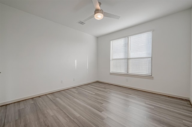 empty room featuring baseboards, light wood-type flooring, visible vents, and a ceiling fan