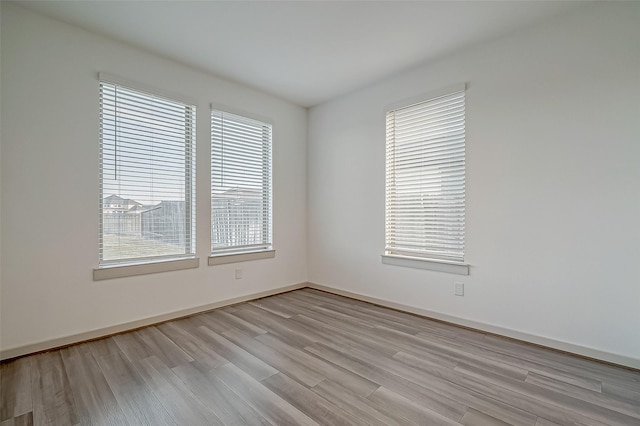 empty room with light wood-style floors and baseboards