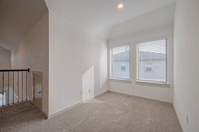 carpeted spare room with lofted ceiling, baseboards, and recessed lighting