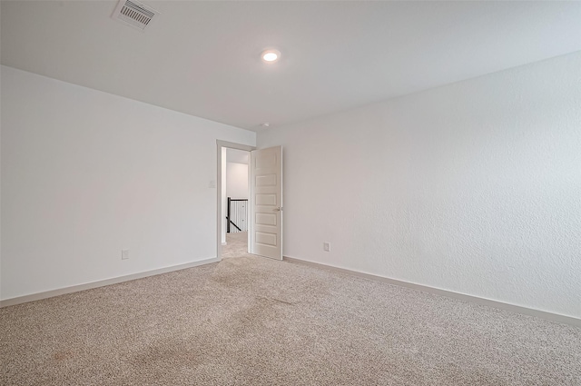 carpeted empty room with baseboards and visible vents