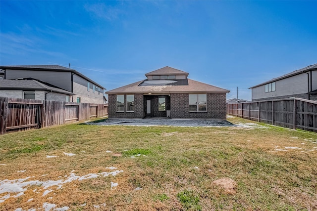 back of house with a patio area, brick siding, a lawn, and a fenced backyard