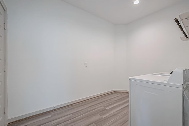 laundry area with recessed lighting, light wood-style floors, separate washer and dryer, laundry area, and baseboards