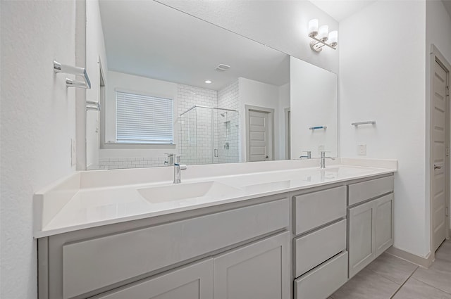 full bathroom with double vanity, a shower stall, visible vents, and a sink