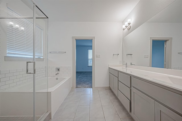 bathroom featuring a garden tub, double vanity, a sink, and a shower stall