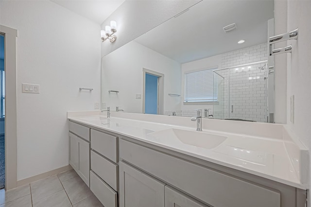 full bath with double vanity, a shower stall, a sink, and tile patterned floors