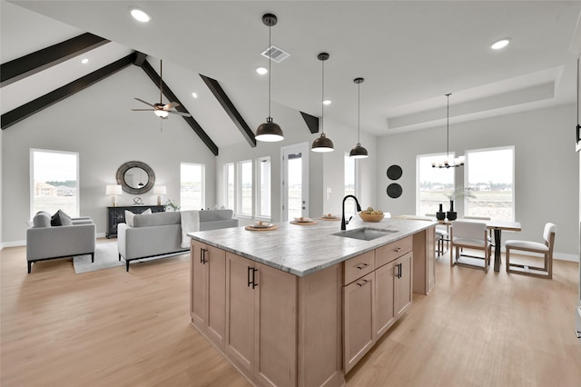 kitchen with light brown cabinetry, a wealth of natural light, a sink, and light wood-style flooring