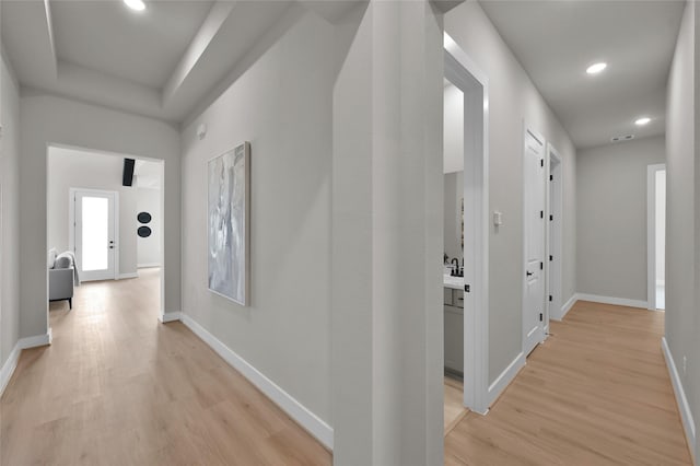 hallway with baseboards, recessed lighting, visible vents, and light wood-style floors