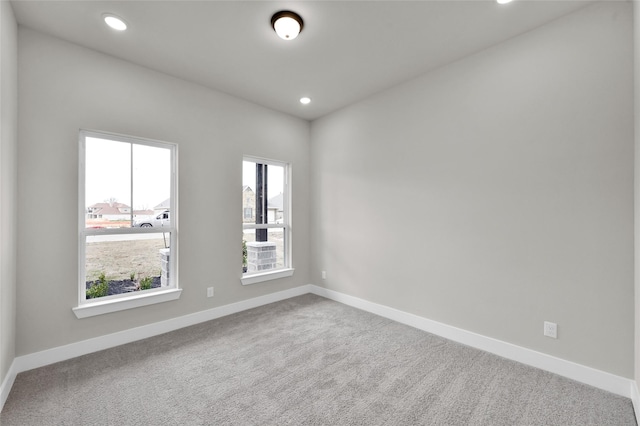 carpeted spare room featuring recessed lighting and baseboards