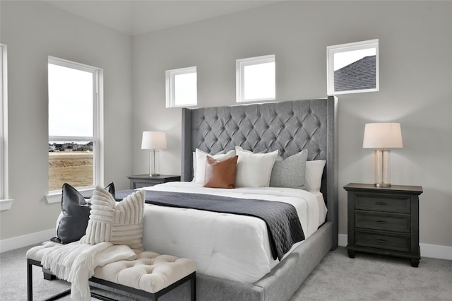 bedroom with baseboards and light colored carpet