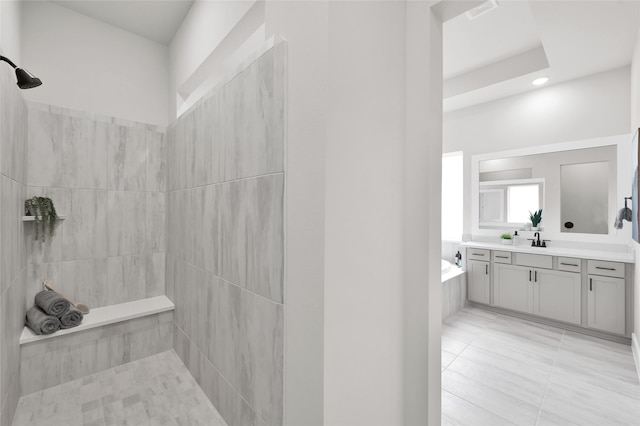 bathroom featuring visible vents, vanity, a tile shower, a bath, and tile patterned floors