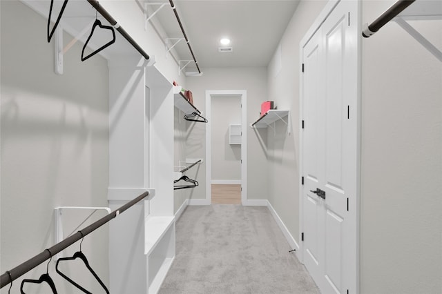 spacious closet featuring light colored carpet and visible vents