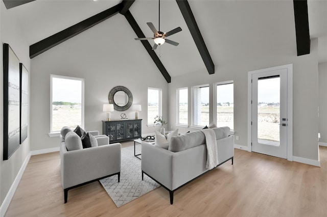 living area featuring light wood finished floors, baseboards, high vaulted ceiling, and beamed ceiling